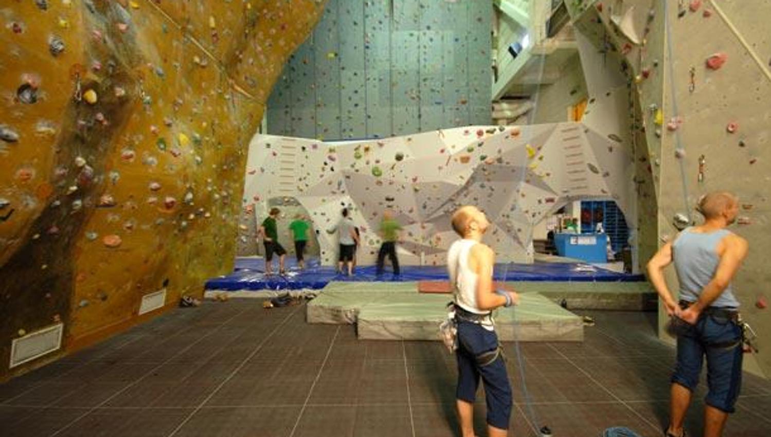 climbing centre with climbing walls and people in climbing clothes