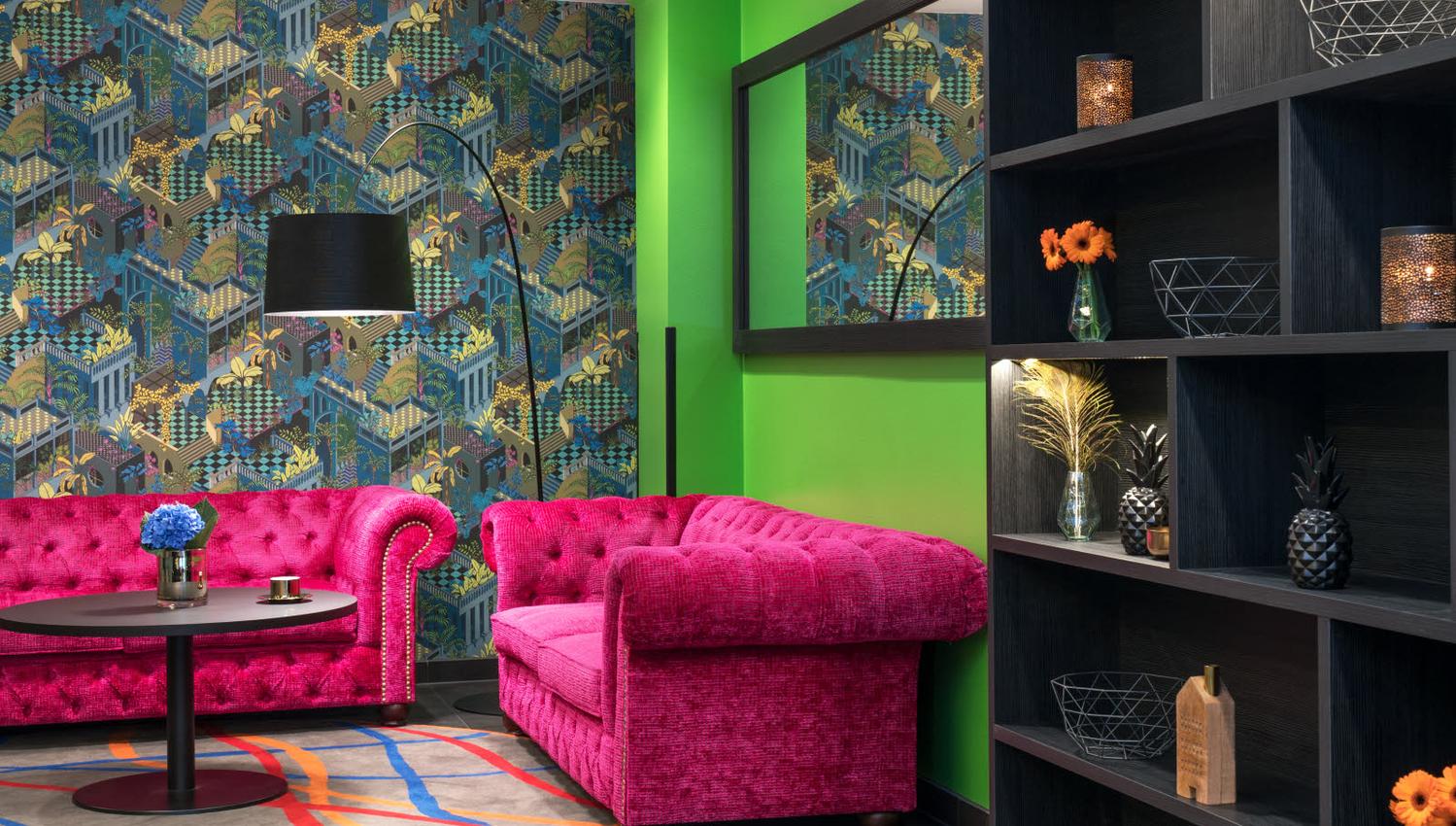 Two pink sofas in front of an apple green wall and a wallpaper wall. Thon Hotel Terminus in Oslo. Photo.
