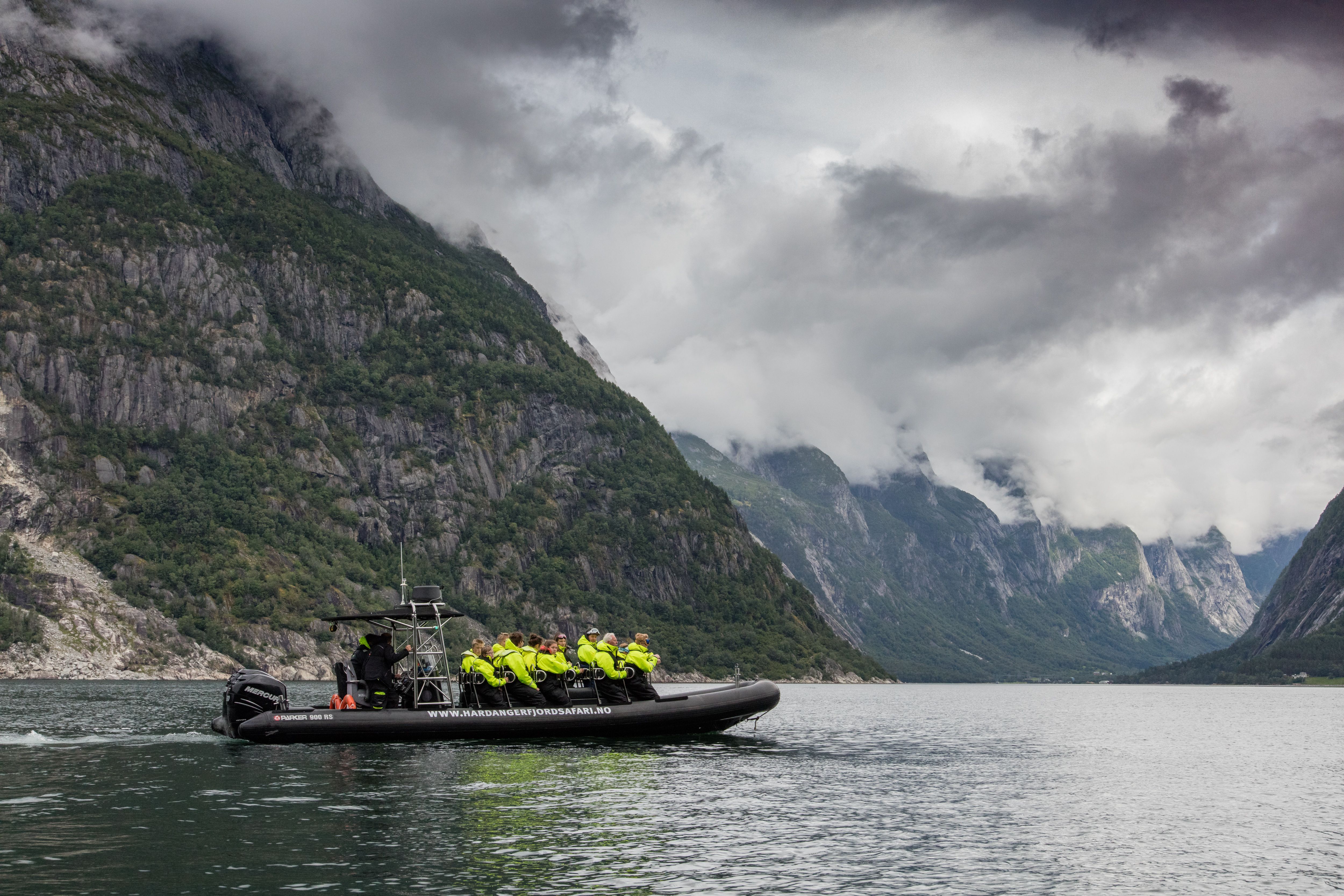 En ribbåt på fjorden, fylt med passasjerer.