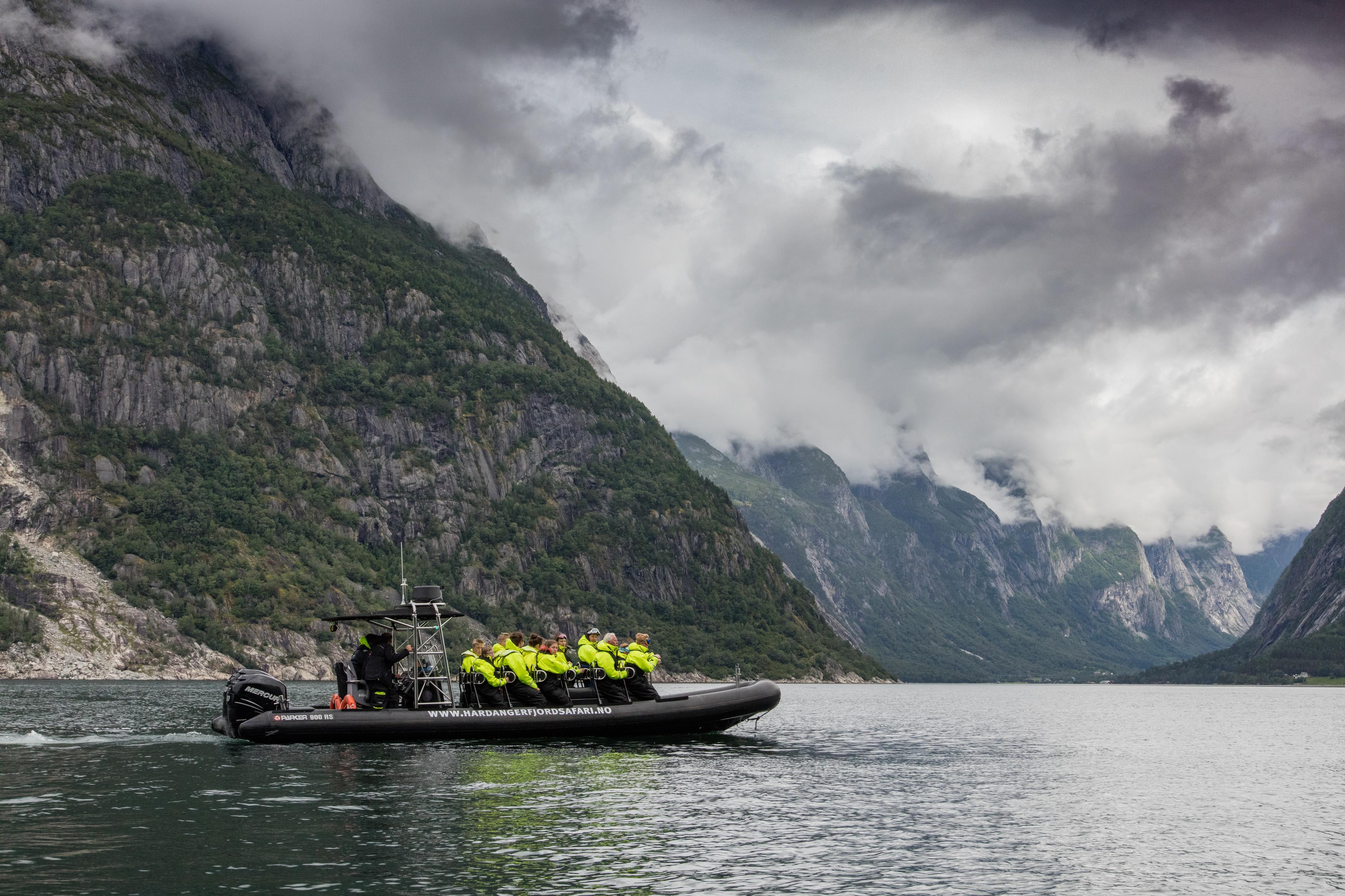 A rib boat on the fjord, filled with passengers.
