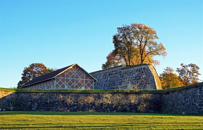 Gressplen, et hus og mur.