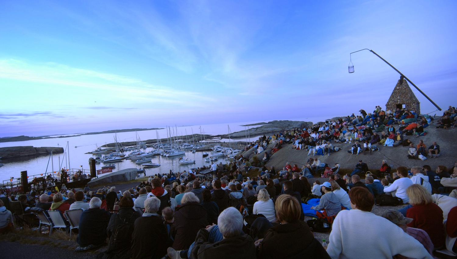 Many people sit at Verdens Ende in the evening