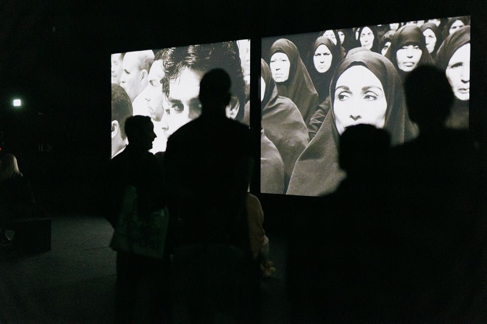 Visitors watching screens in a dark room
