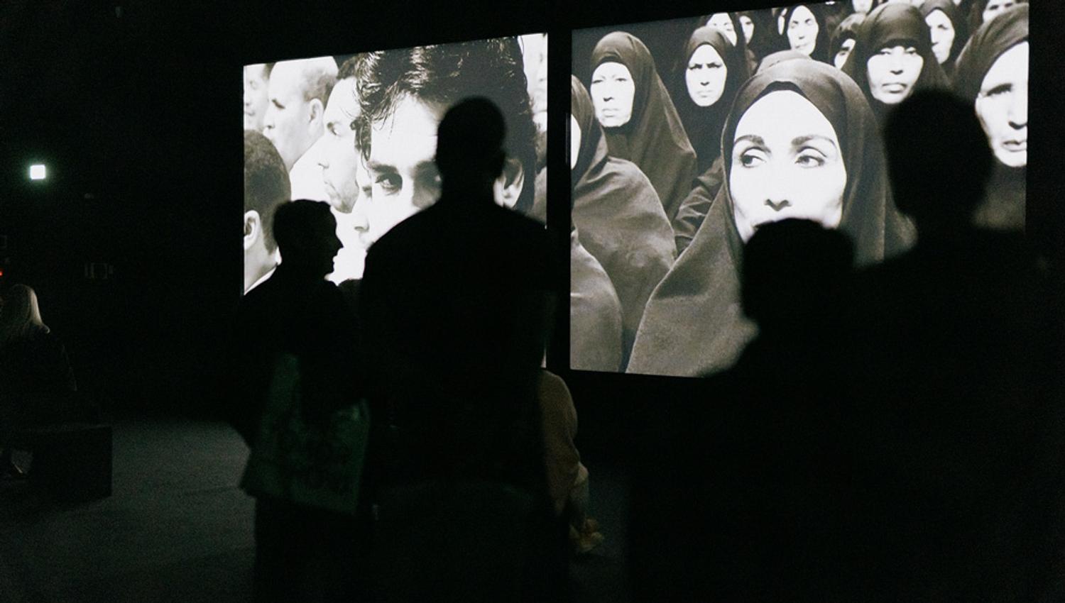 Visitors watching screens in a dark room