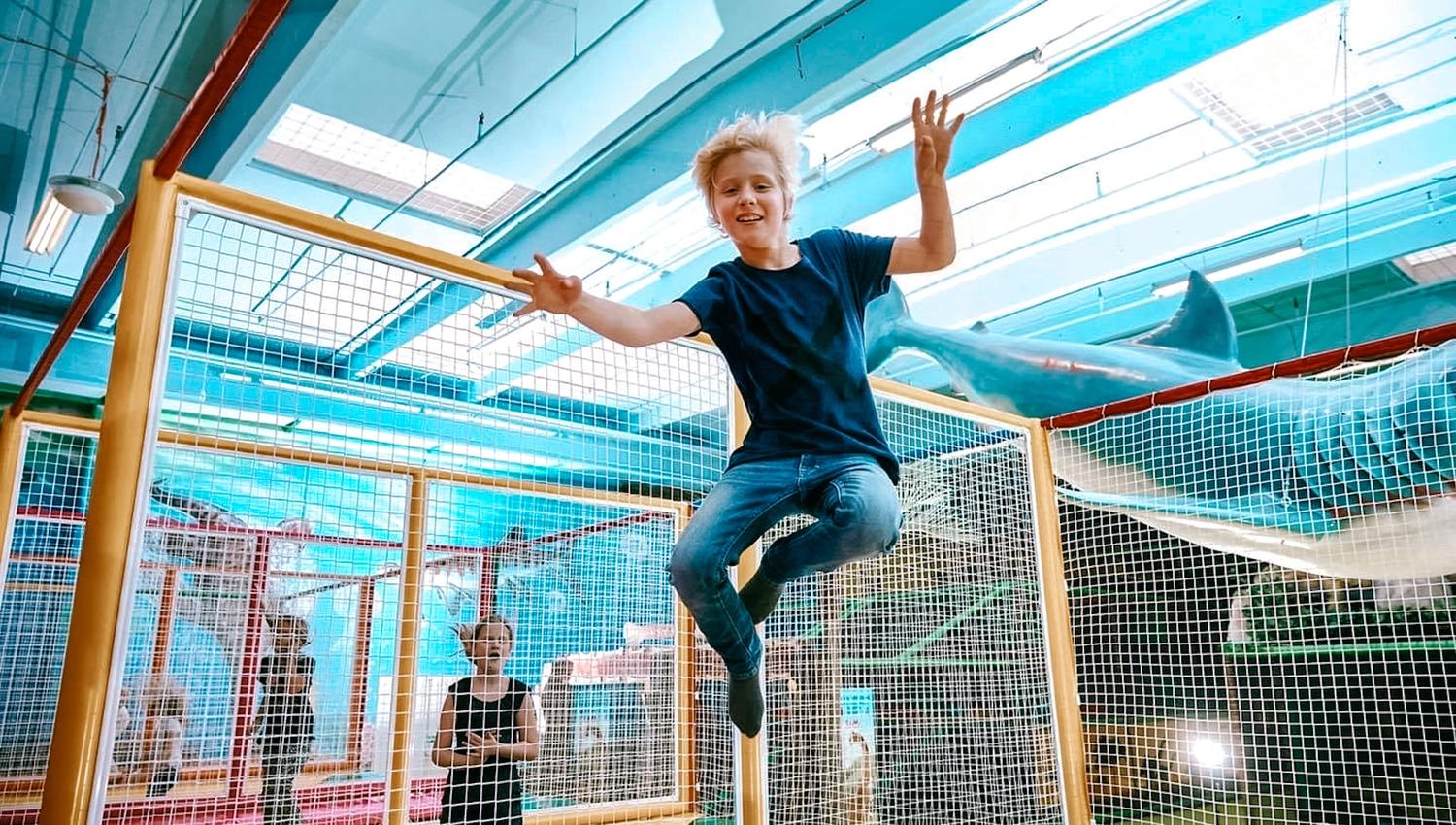 Barn som hopper på trampoline. Foto.