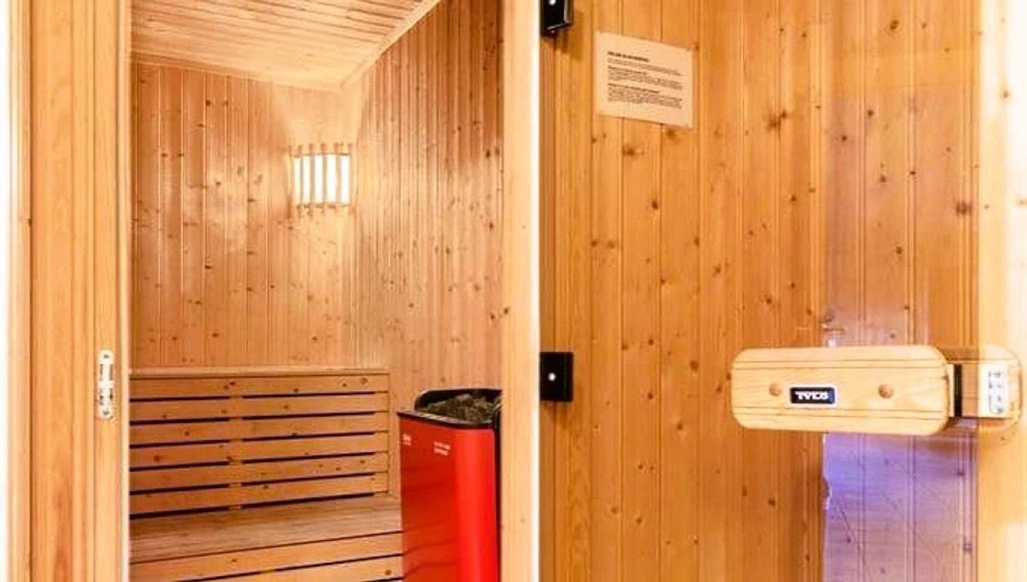 A wooden room with a red fridge.