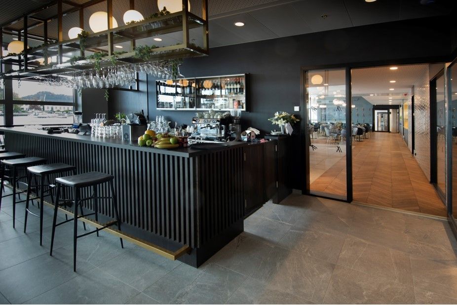 Svart bar med svarte barstoler på Mandal Hotel