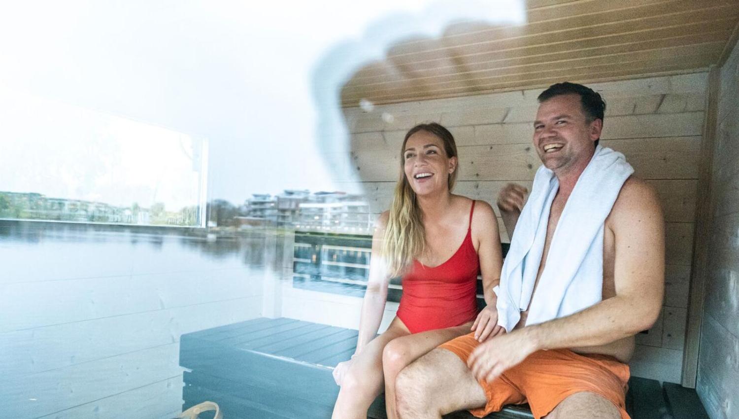 Mann og dame som sitter i badstuebåten Leo på Hjellevannet i Skien
