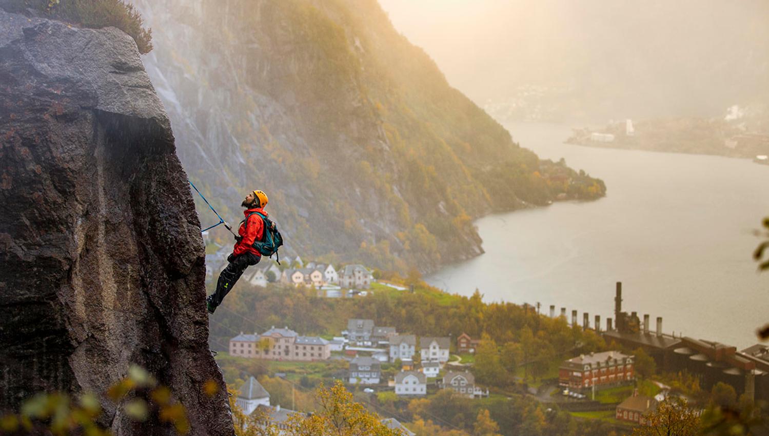 Klatrar på Via Ferrata Tyssedal med utsikt mot Sørfjorden og industristaden.