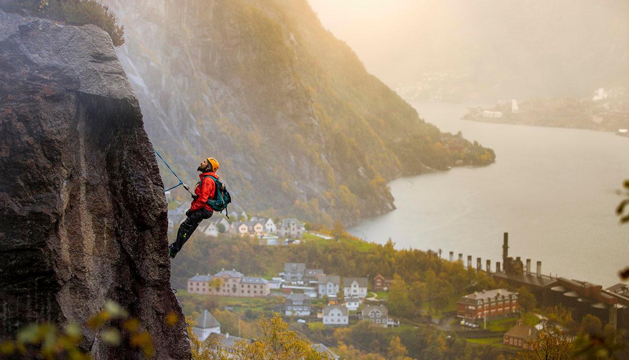 Climber on Via Ferrata Tyssedal with panoramic views over the Sørfjorden.
