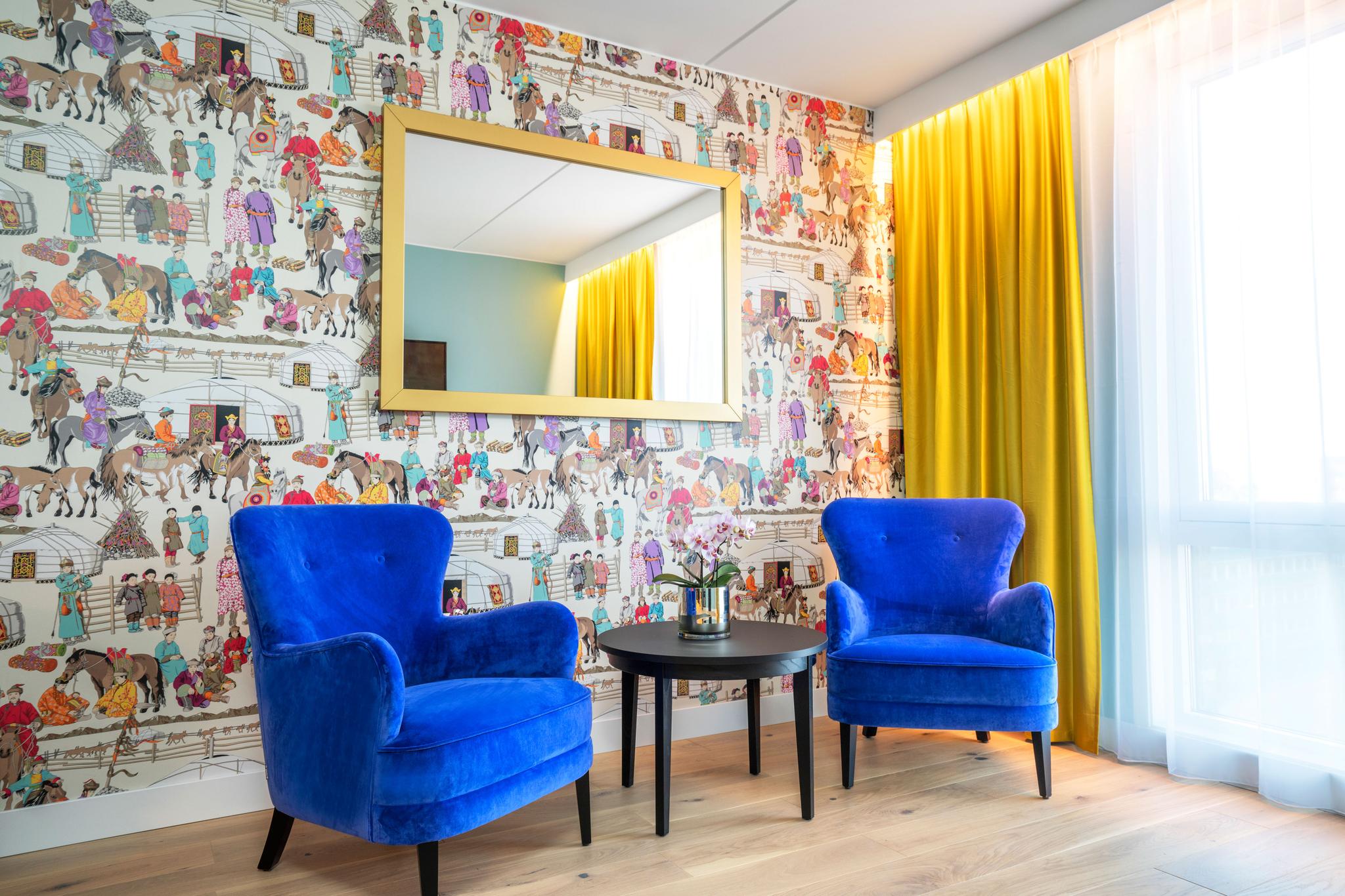 Blå stoler foran farget tapet. Gule gardiner. Tregulv. Thon Hotel Storo, Oslo. Foto