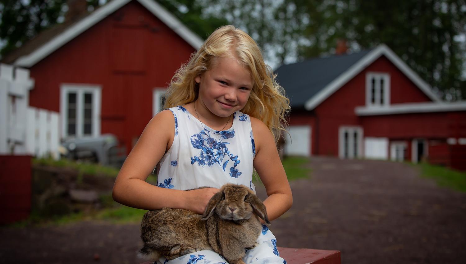 A child cuddles a rabbit