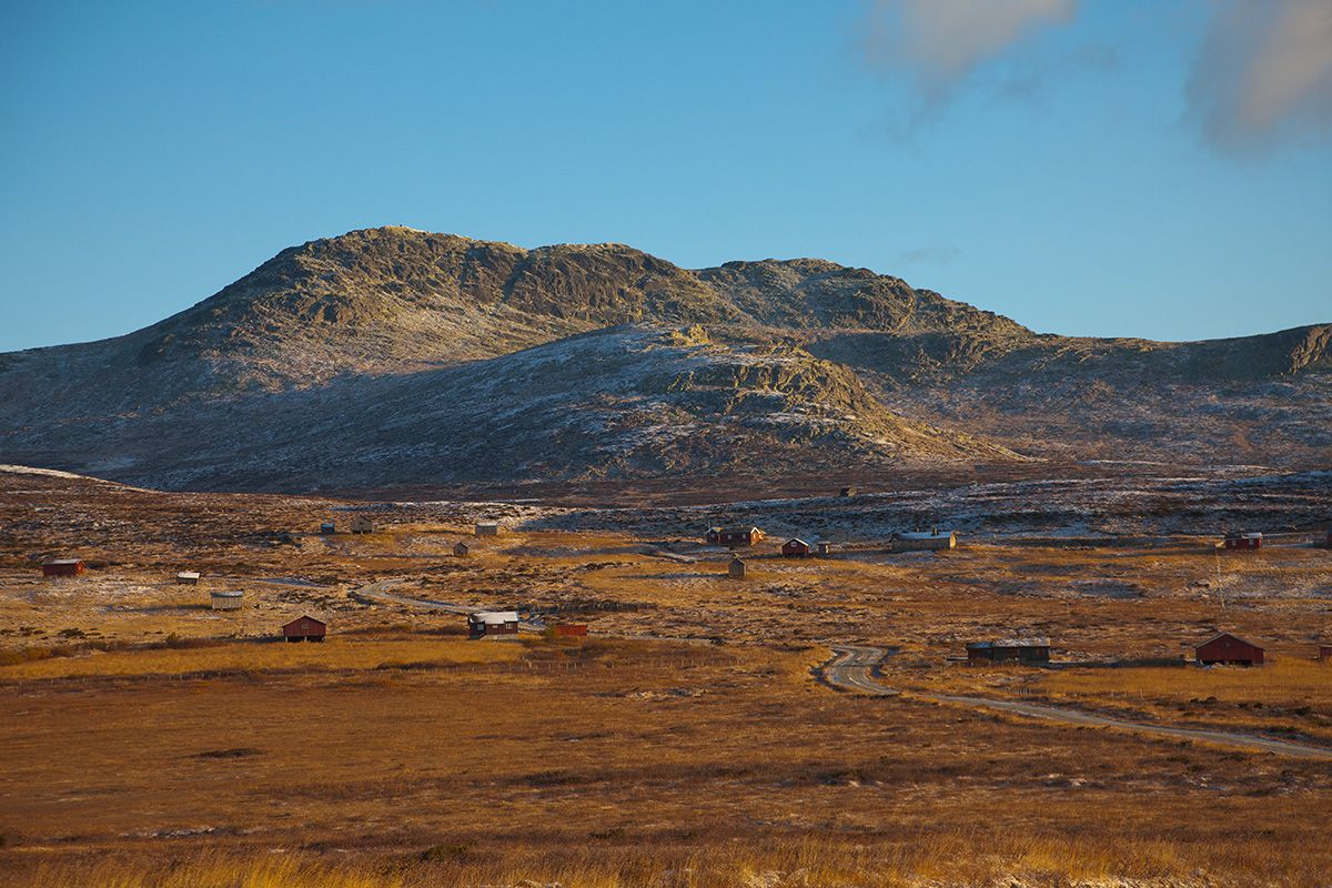 Skaget rises over the summer mountain farming area of Vesleskag. The vegetation is autumn coloured, and the first snow has fallen on the high altitude