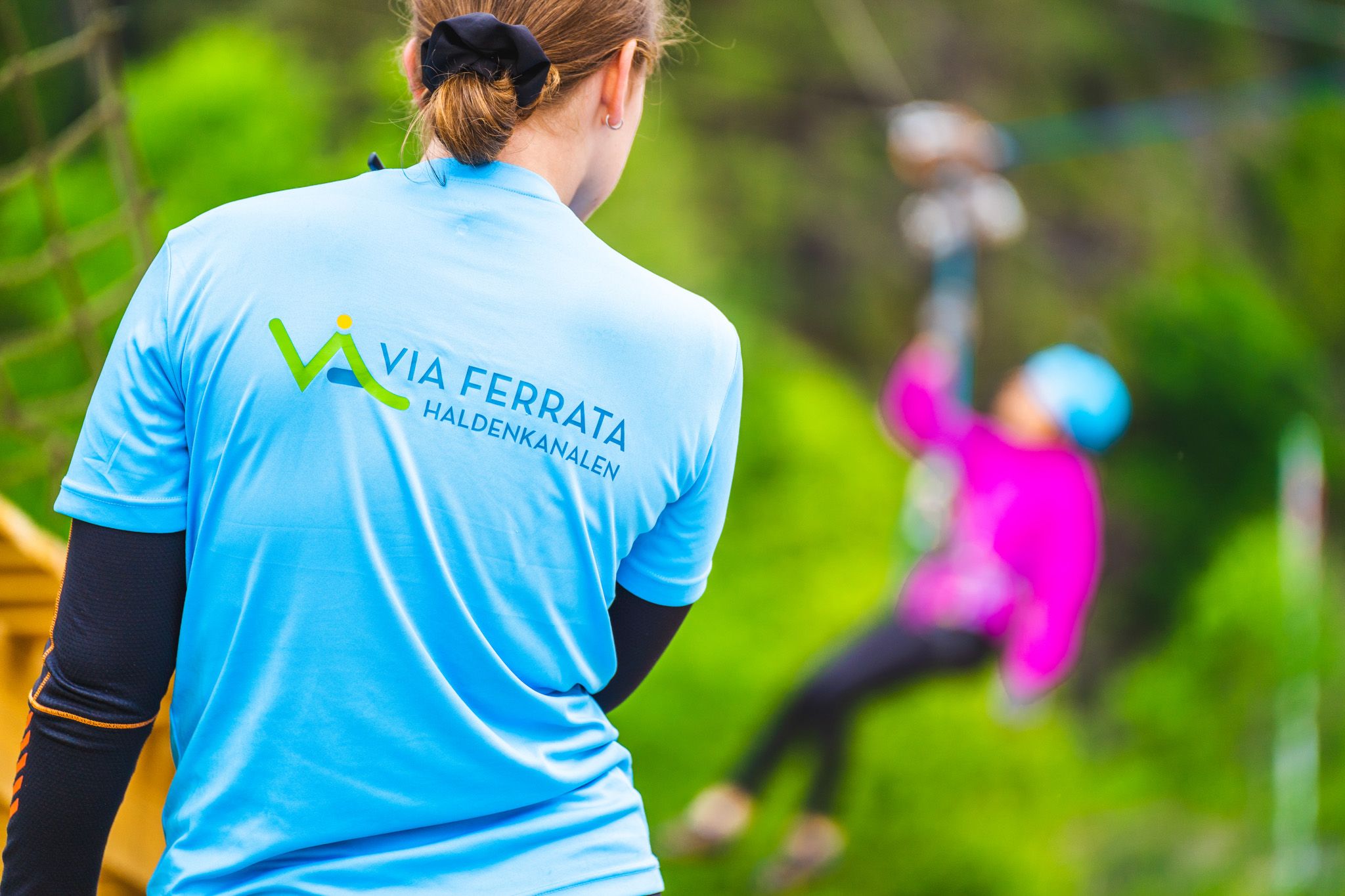 En av klatreguidene står klar for å ta imot de som kommer ned zip-linen.