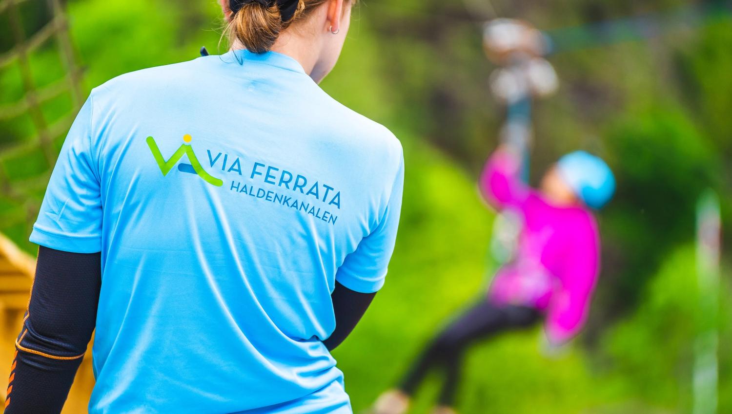 En av klatreguidene står klar for å ta imot de som kommer ned zip-linen.