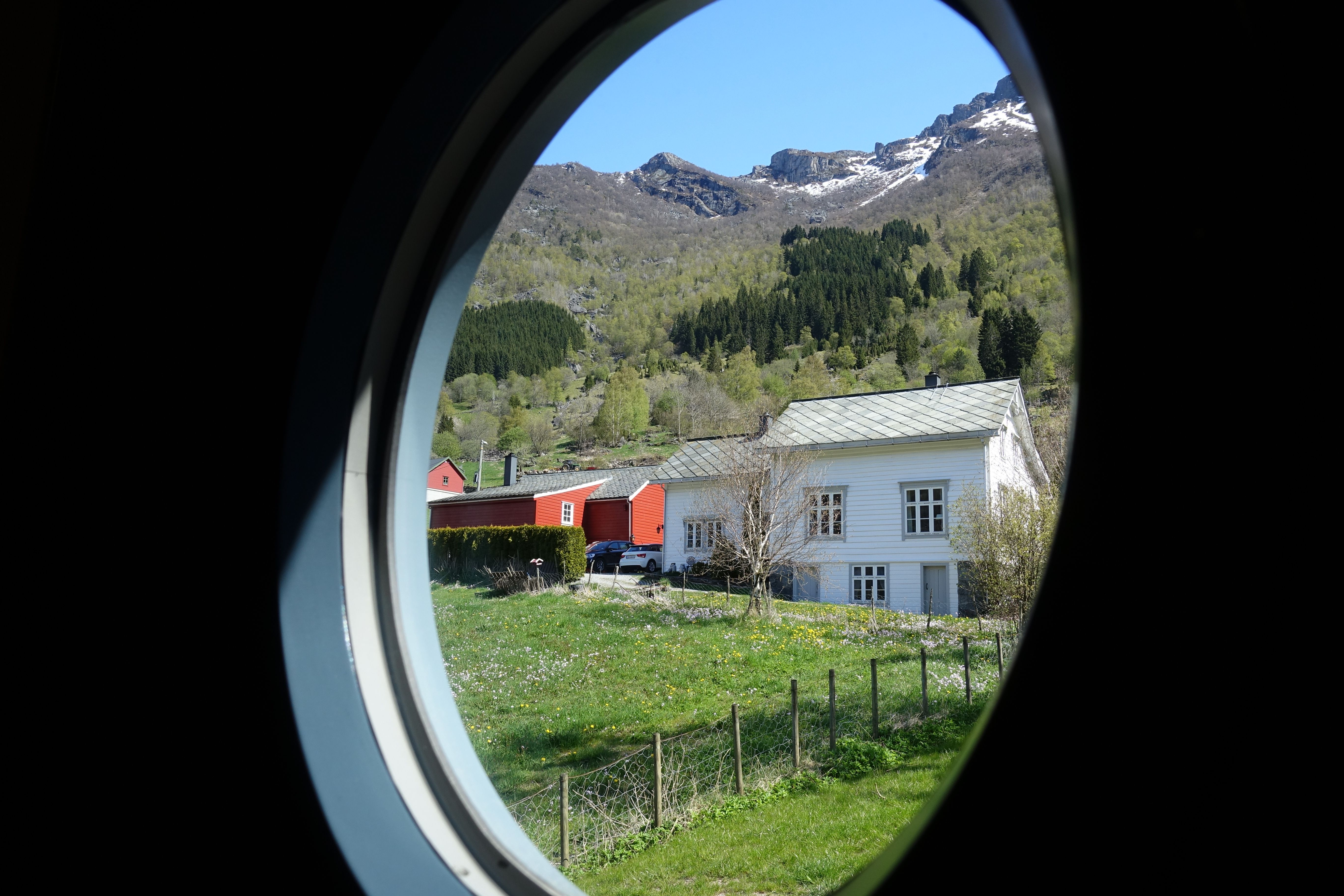 Magisk utsikt mot fjella og landskapet i Hardanger frå eit rundt hotellvindauge.