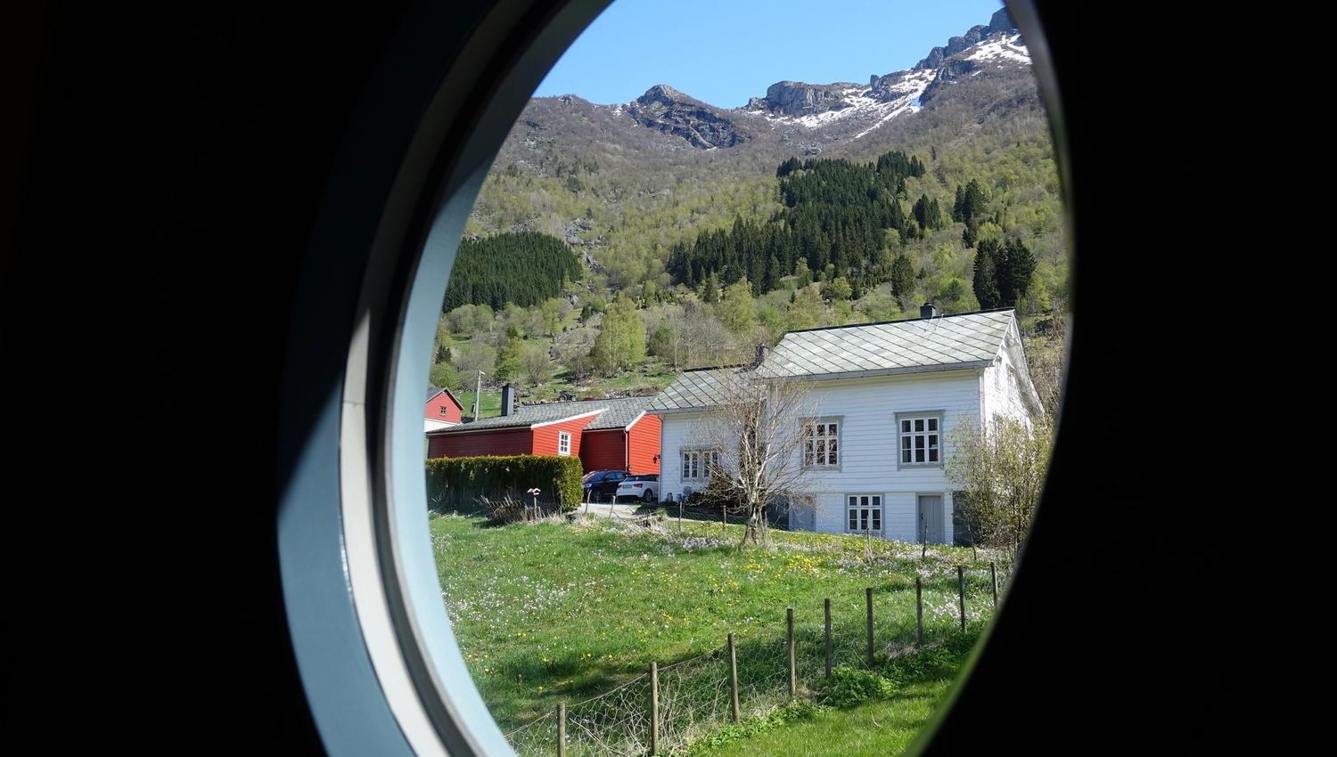 Magisk utsikt mot fjella og landskapet i Hardanger frå eit rundt hotellvindauge.