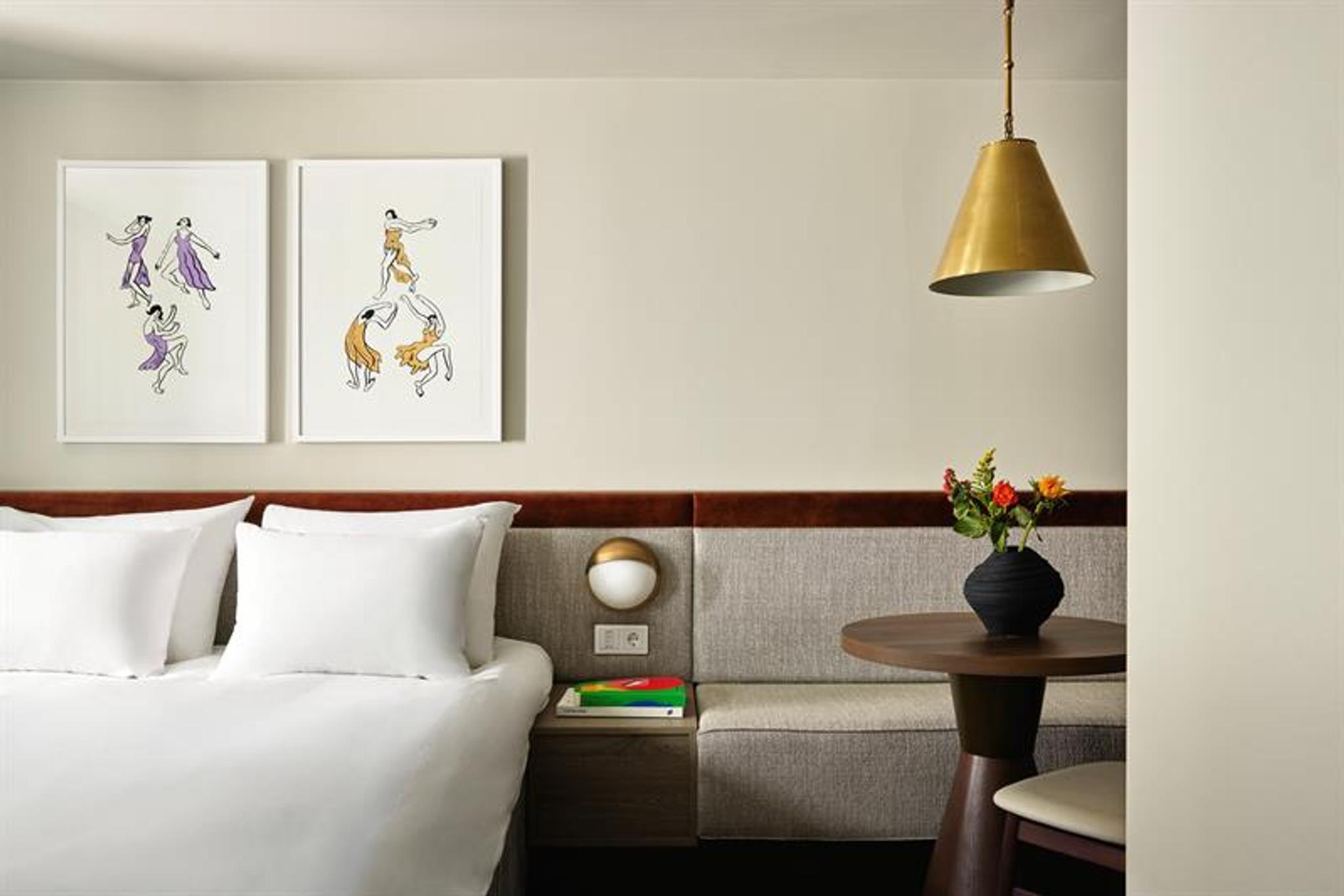 Rommene har dobbeltseng, integrert sitteplass og veggmontert belysning. Interiøret kombinerer tekstiler, treverk og innrammet kunst.