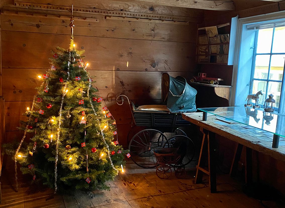 Eit pynta juletre og ei gamaldags barnevogn