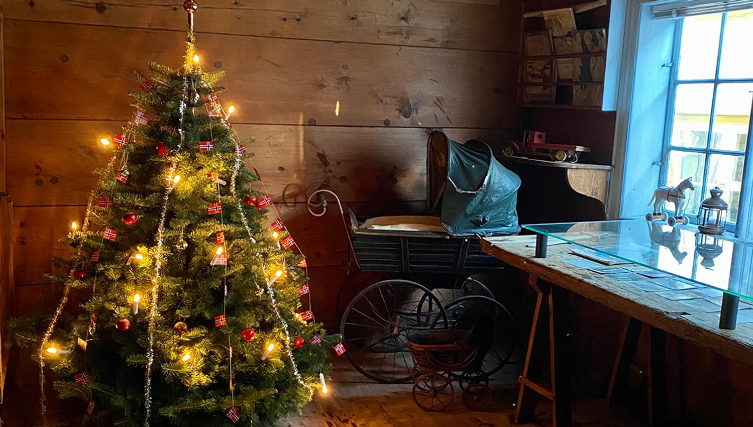 Eit pynta juletre og ei gamaldags barnevogn