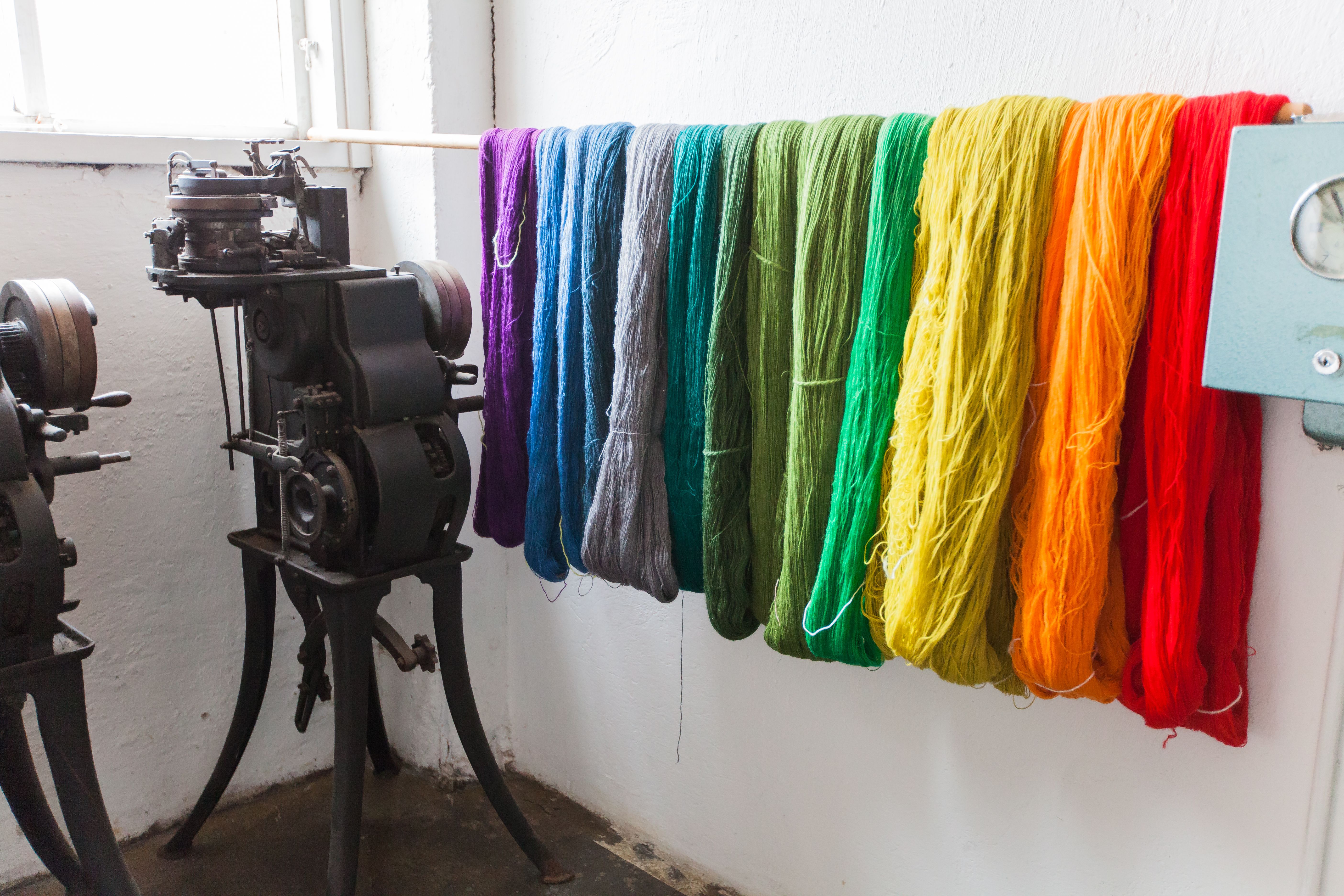 Yarn in various colors: purple, blue, gray, shades of green, yellow, orange, and red.