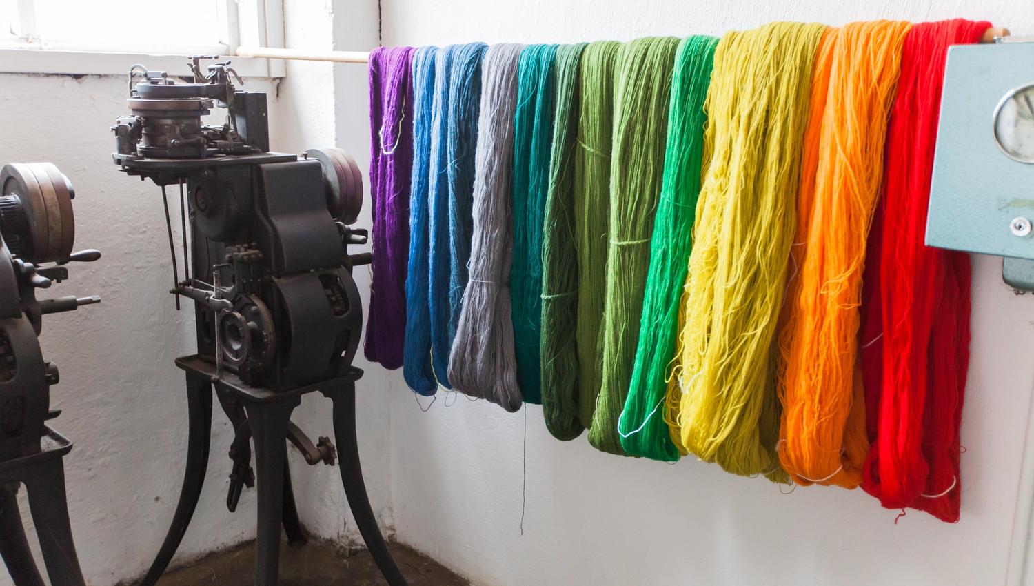 Yarn in various colors: purple, blue, gray, shades of green, yellow, orange, and red.