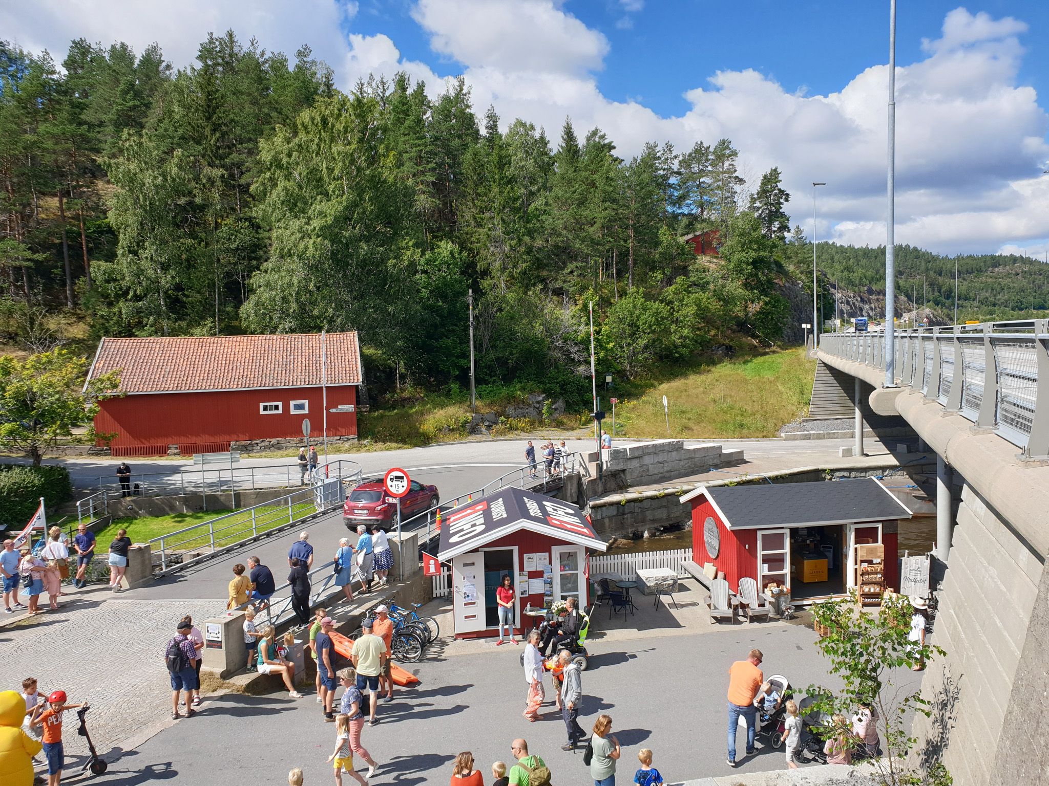 Turistinformasjonen med folkelivet rundt bua sett fra oven