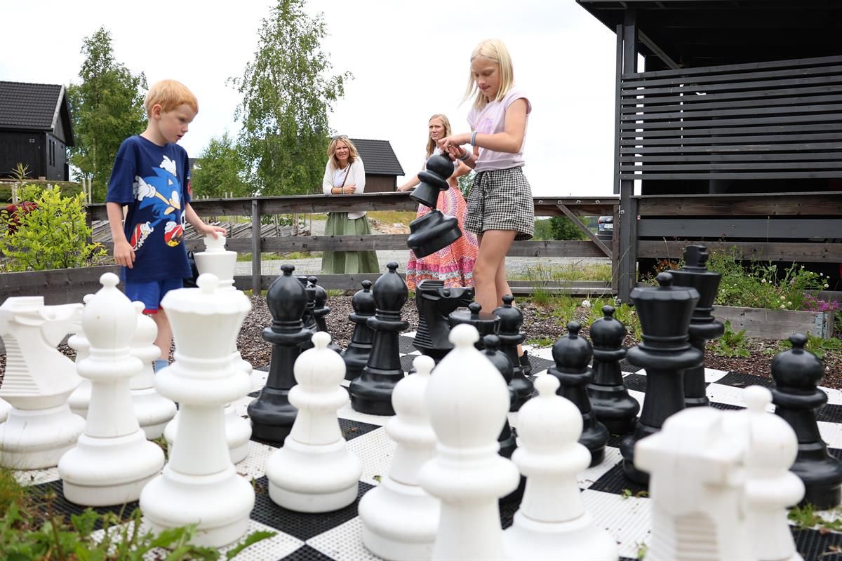 Large outdoor chess set with people moving the pieces.