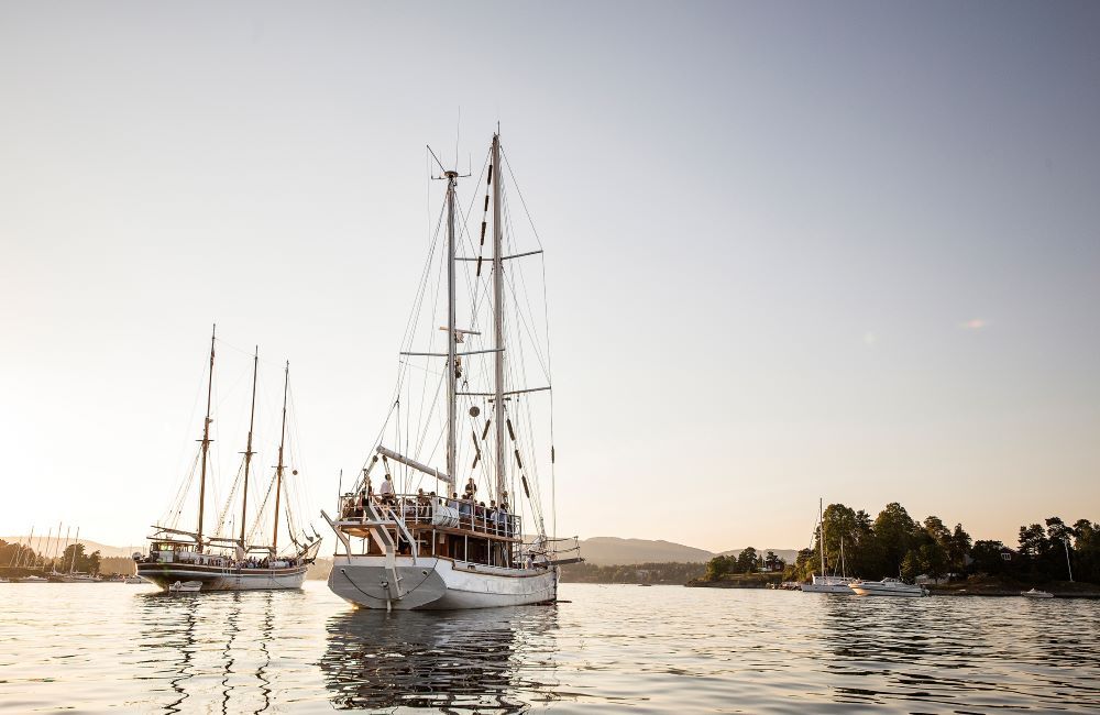 Nyt deilig mat og drikke på Dinner cruise mens solen synker i havet