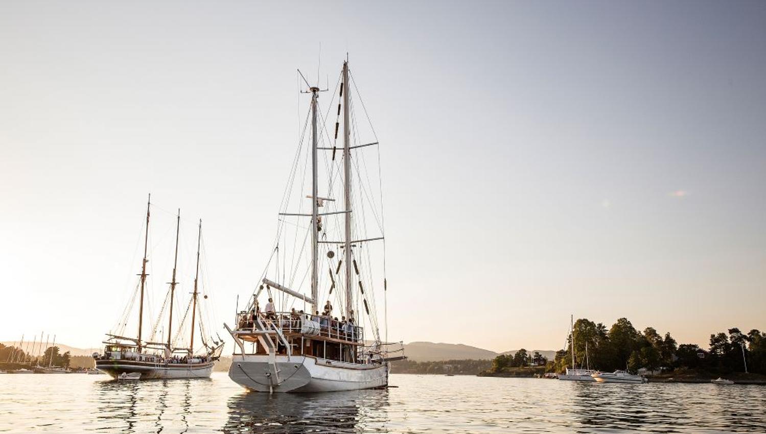 Nyt deilig mat og drikke på Dinner cruise mens solen synker i havet