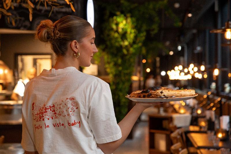 Female server carrying a plate of pizza