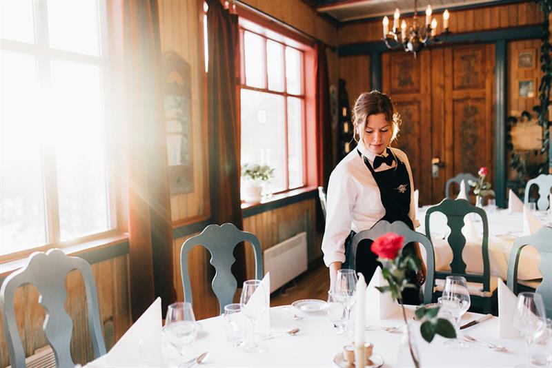 servitrise dekker bord på restaurant på Tuddal Høyfjellshotell