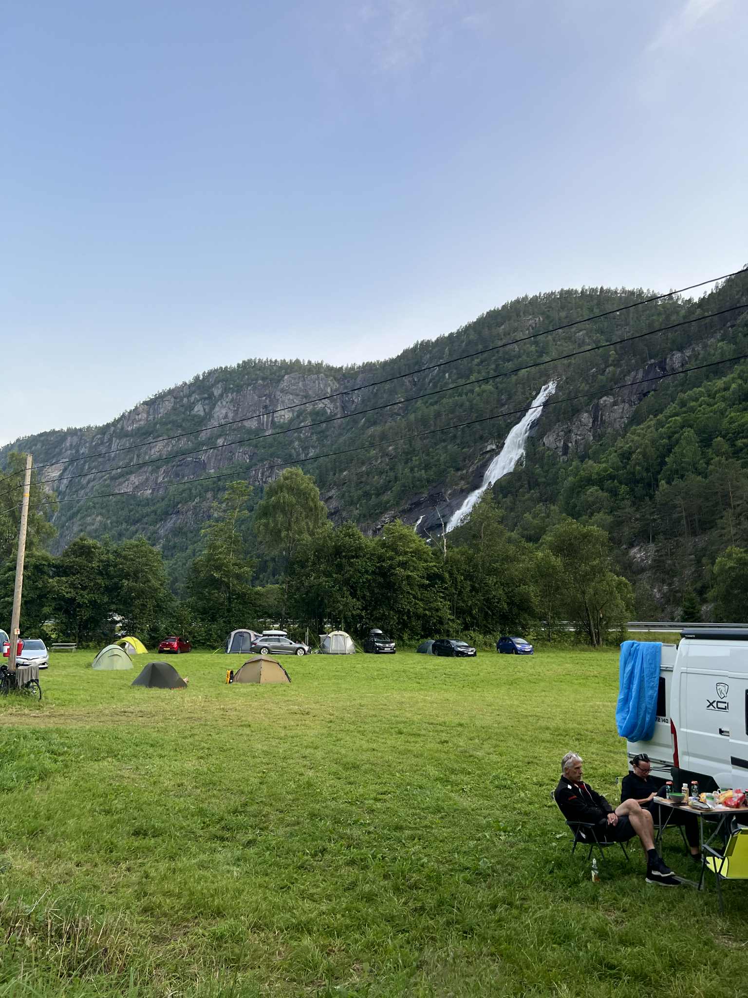 Gjester kosar seg på Hildal Camping med utsikt mot fossen i Oddadalen.