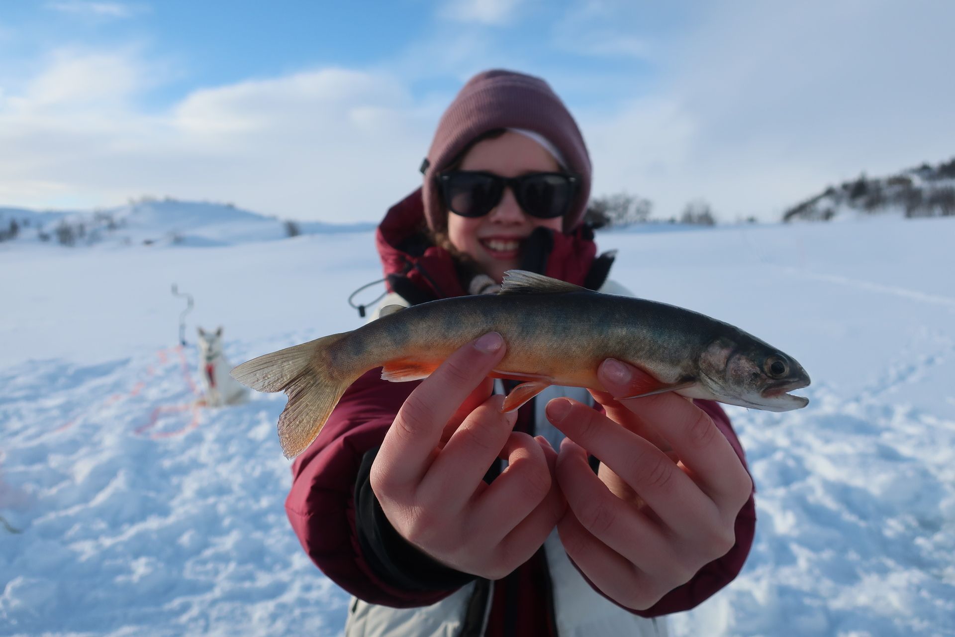 Child is holding a trout. 