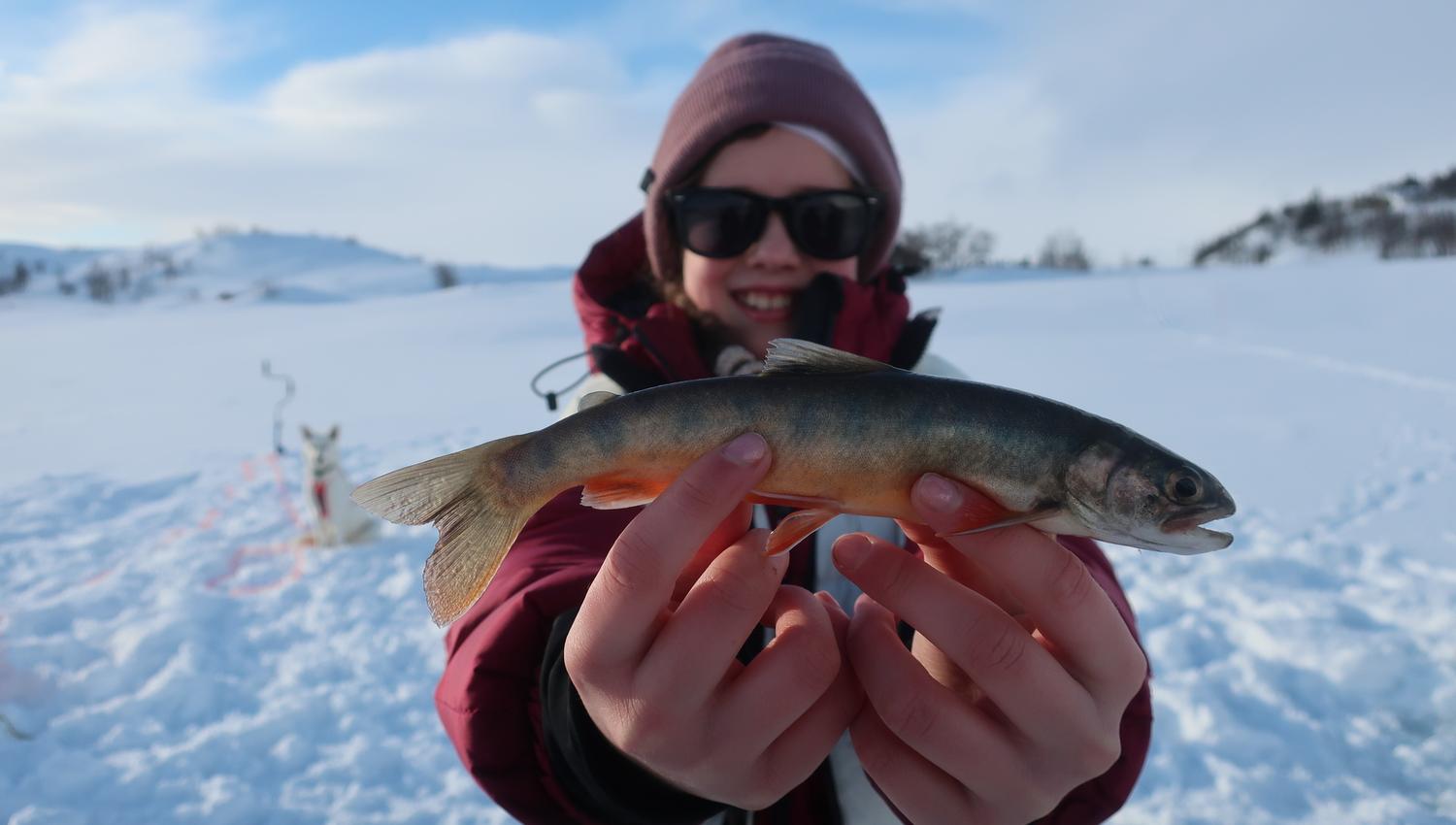 Child is holding a trout.
