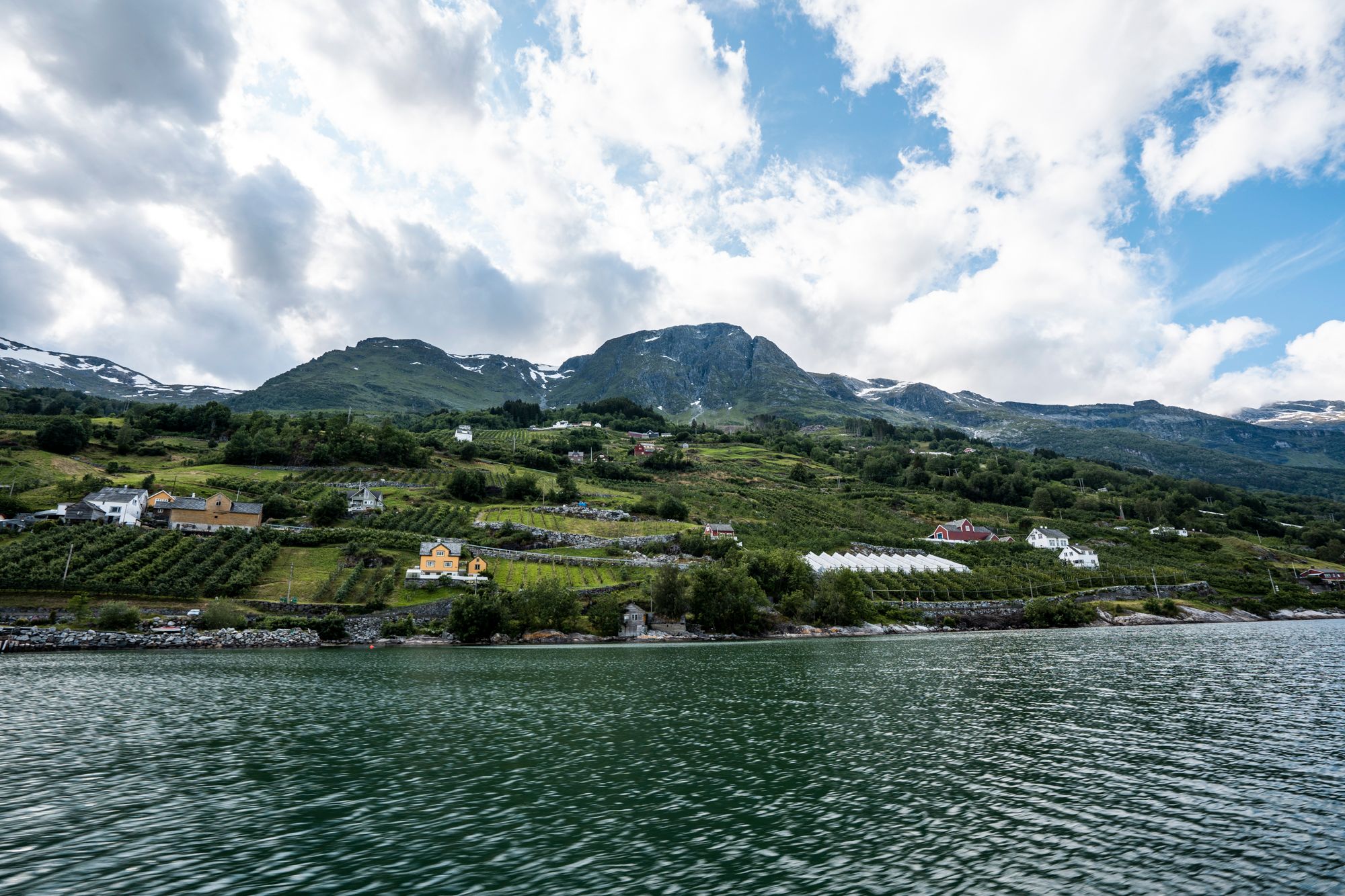 Waves meet lush fruit orchards along the Hardangerfjord.