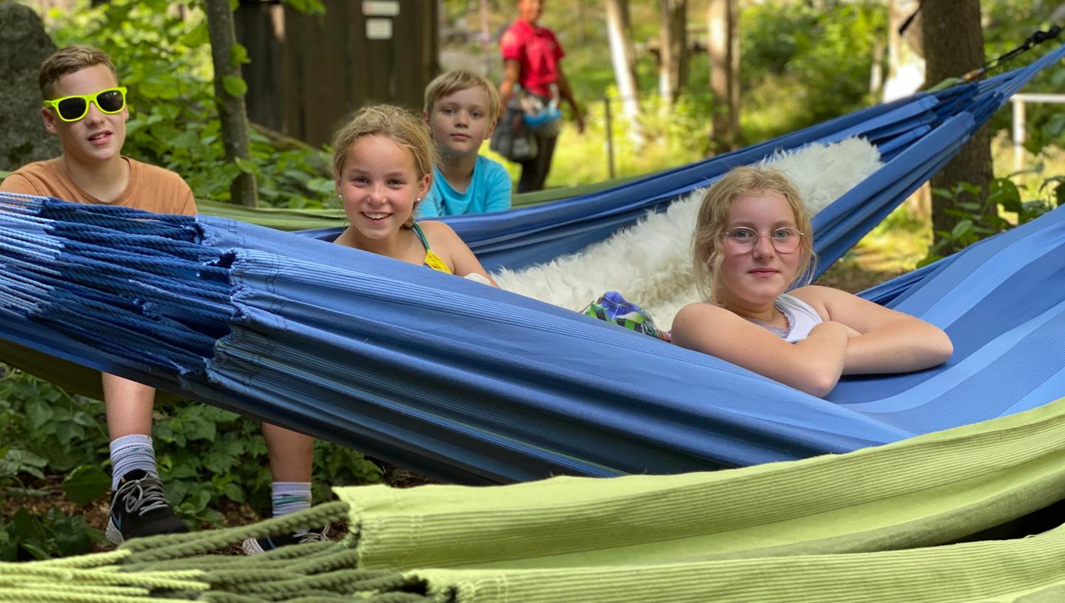 En familie overnatter i hengekøyer