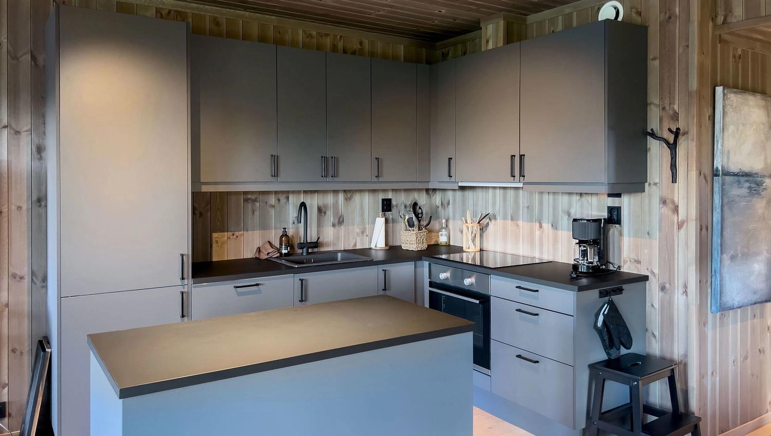A kitchen with worktop and stool.