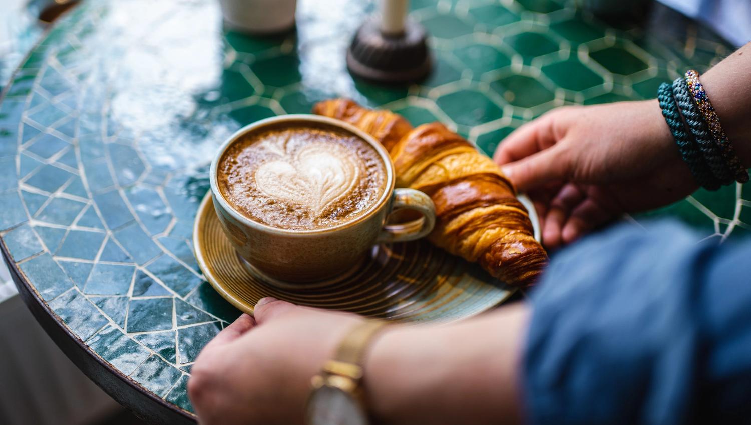 et brett med kaffe og en croissant