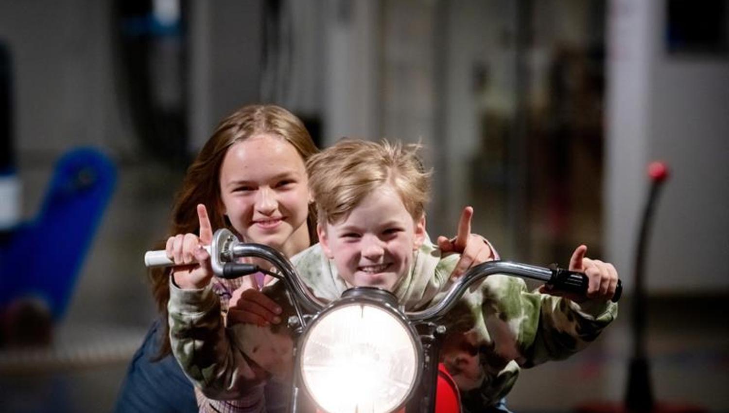 To barn som sitter på en motorsykkel