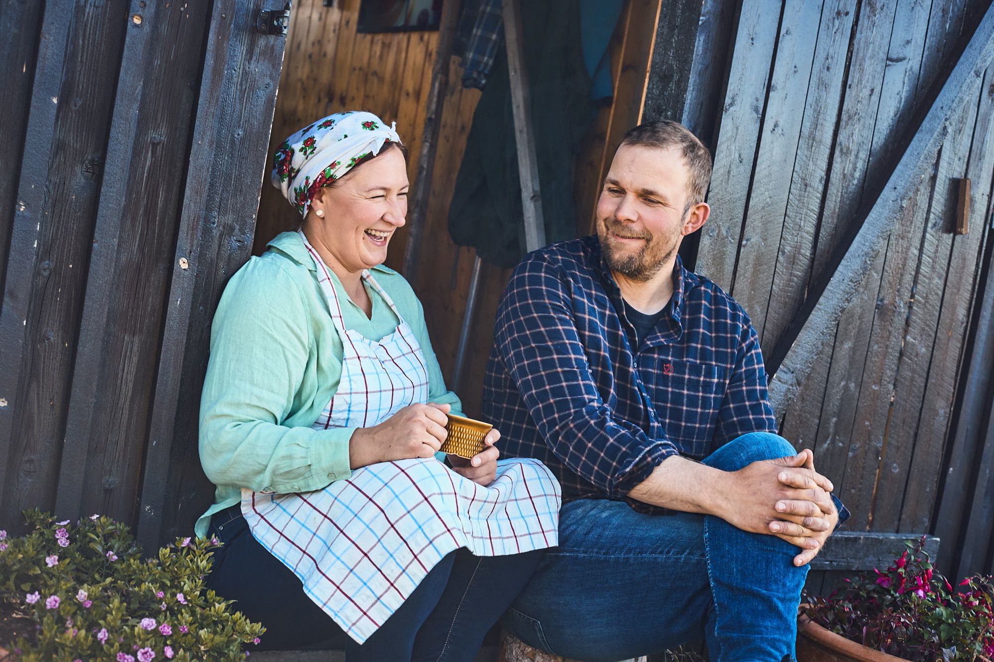 To personer som sitter på trappa med en kaffekopp.