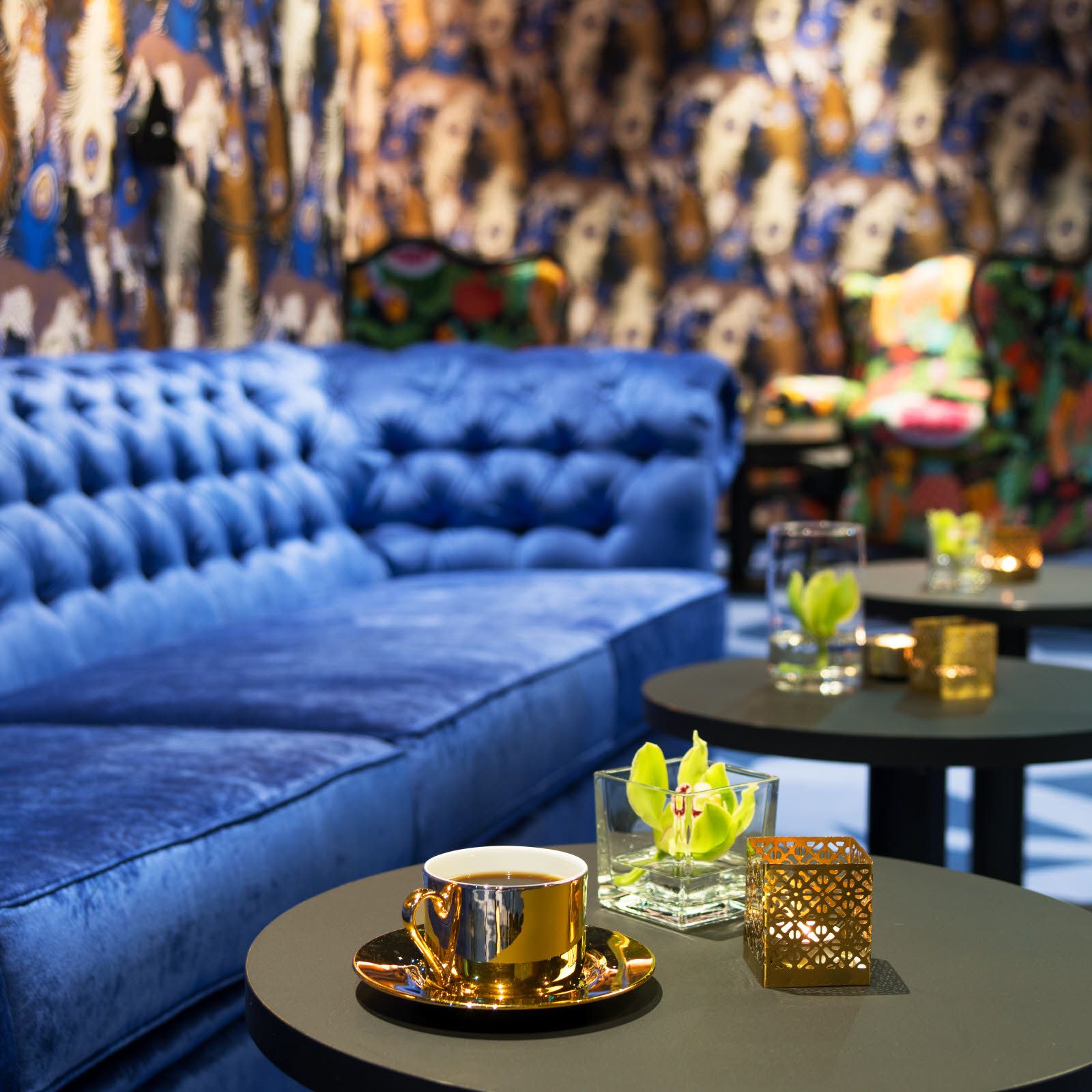 Blue sofa and brass coffee cup. Lounge at Thon Hotel Terminus in Oslo. Photo.