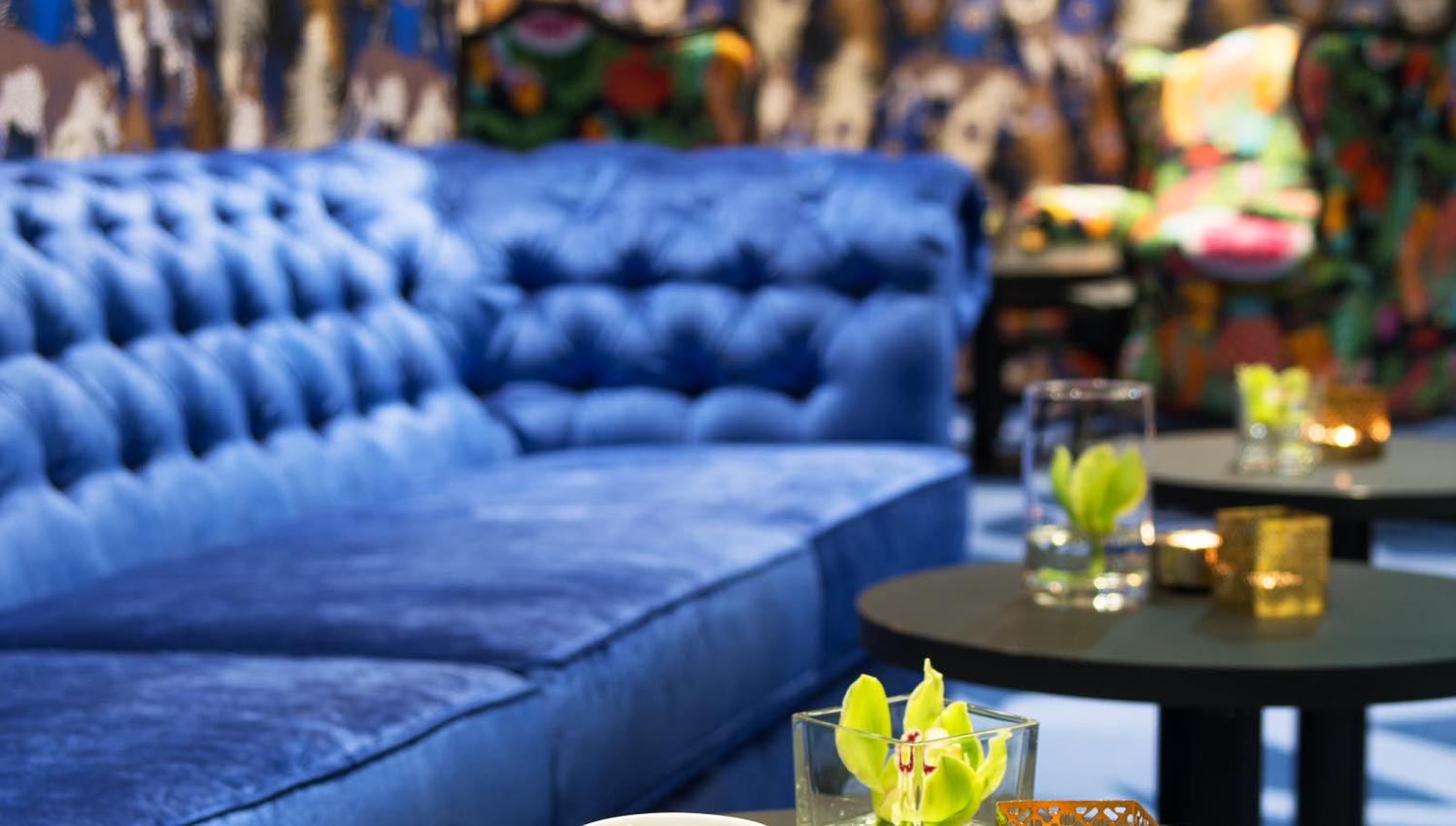 Blue sofa and brass coffee cup. Lounge at Thon Hotel Terminus in Oslo. Photo.