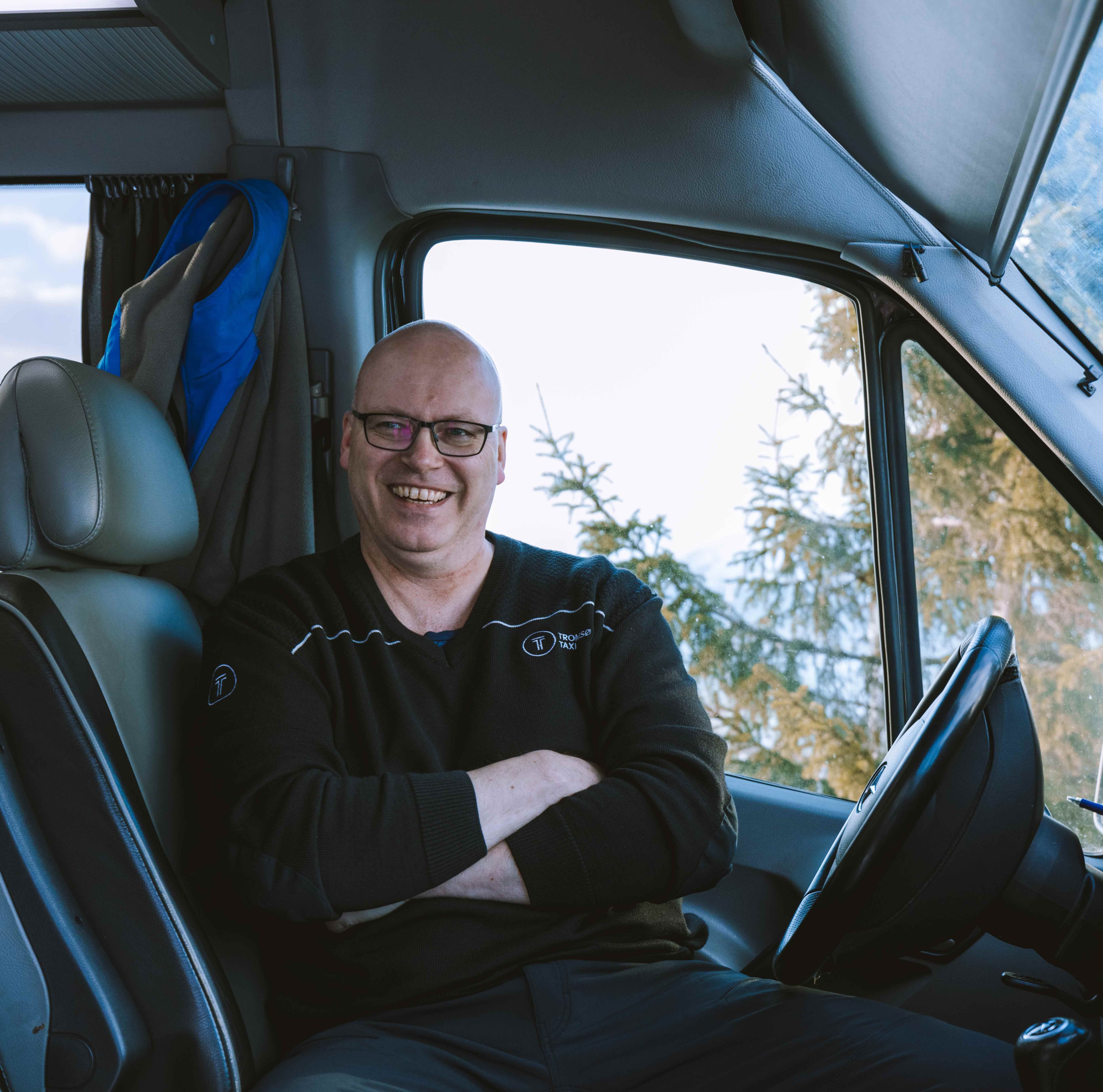 Smilende sjåfør i førersetet.