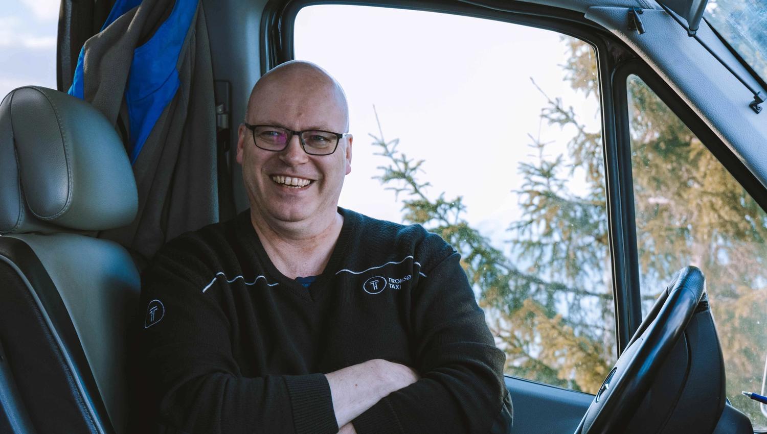 Smilende sjåfør i førersetet.