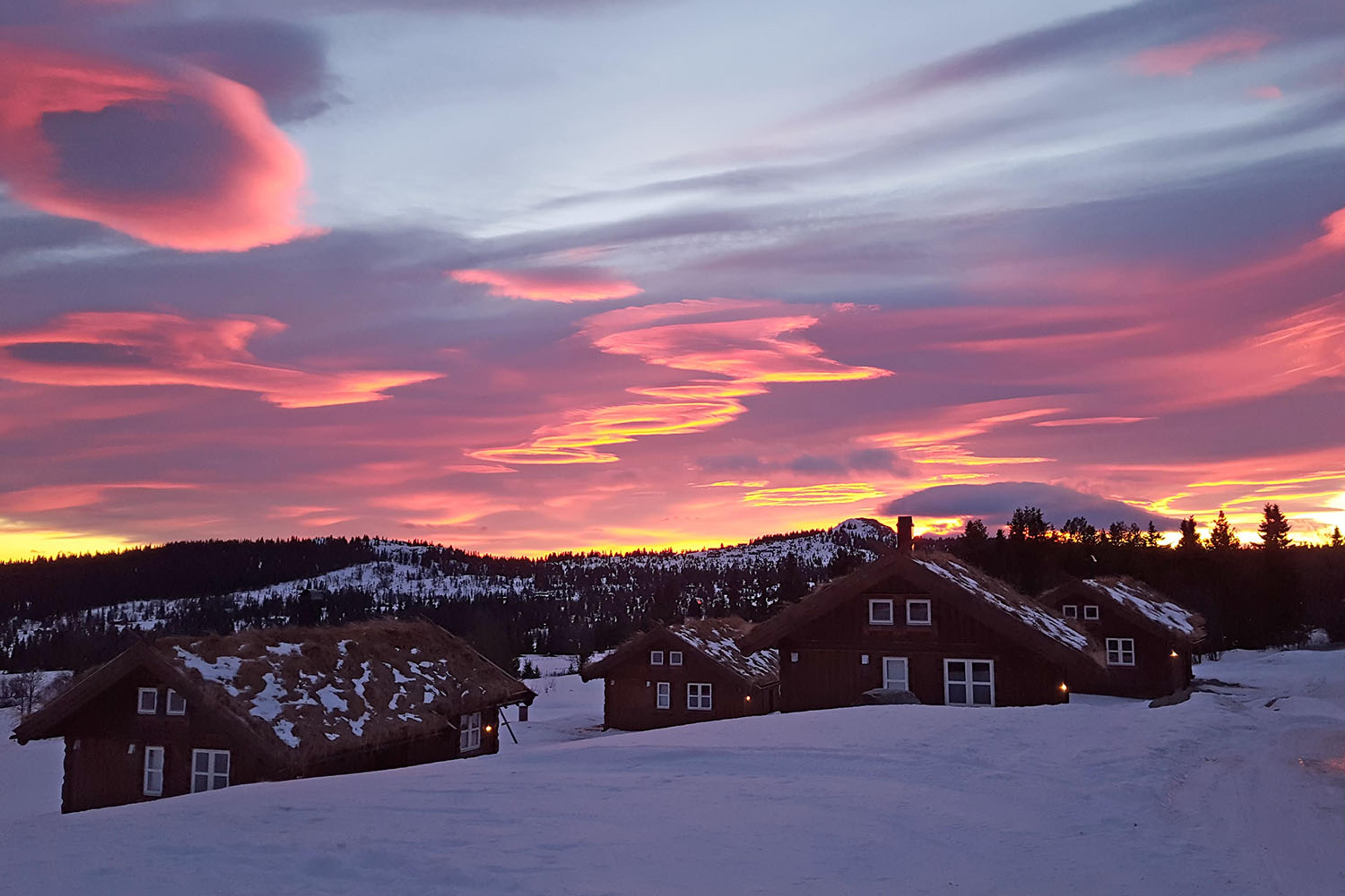 Small wooden cabins in a winter landscape in the sunset