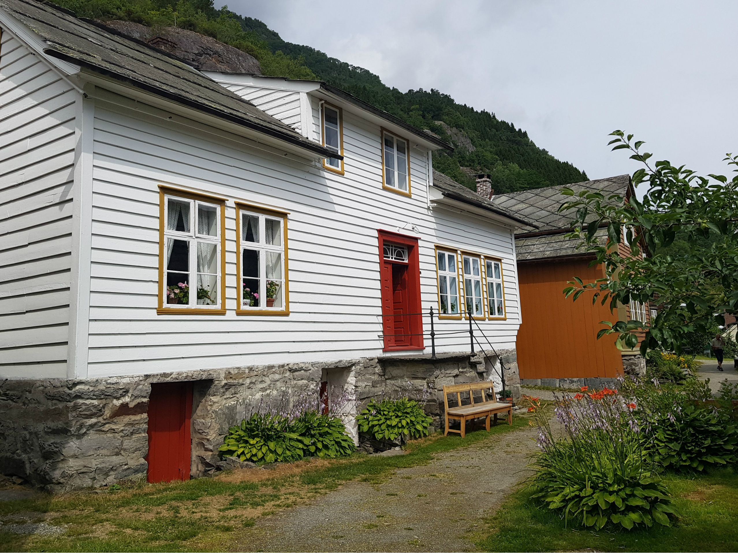 eit kvitt og eitt oransje hus med benk utanfor