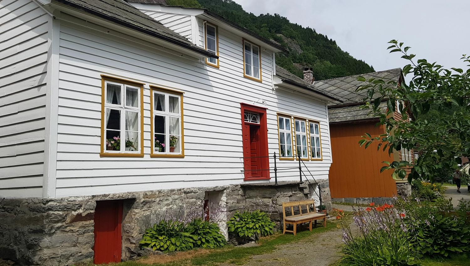 eit kvitt og eitt oransje hus med benk utanfor