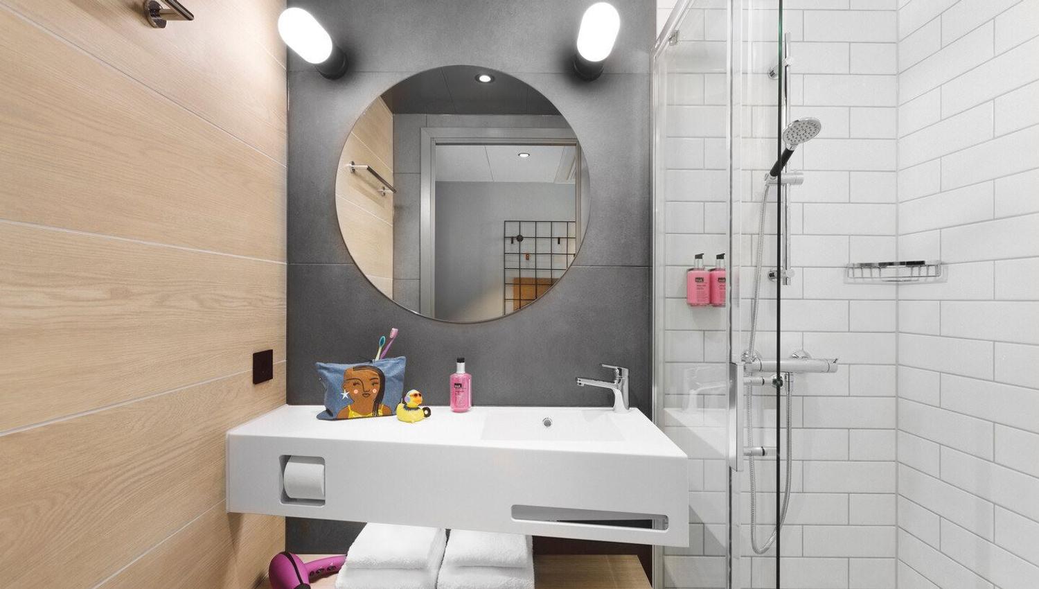 Bathroom in a standard room with a sink, shower and toilet.