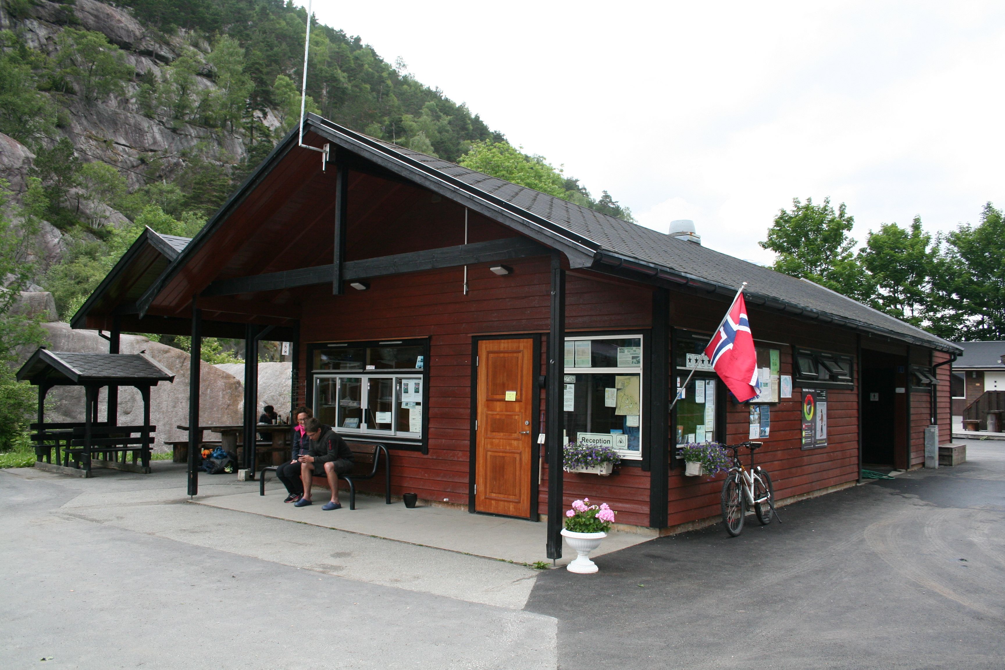Campingresepsjon med uteområde og sitjeplassar ved fjellet.